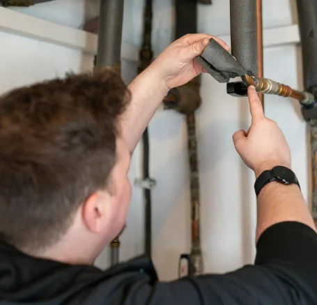 Energieberater bei der technischen Prüfung einer Heizungsanlage.