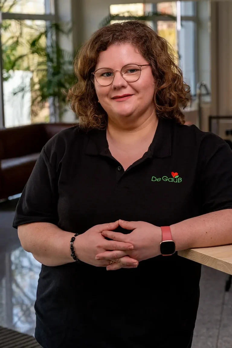 Andrea Gauß – Ihre Expertin für Förderservice & Organisation Andrea Gauß von Energieberater De Gauß lächelt sympathisch in schwarzer Arbeitskleidung mit Firmenlogo – sie leitet das Backoffice und den F