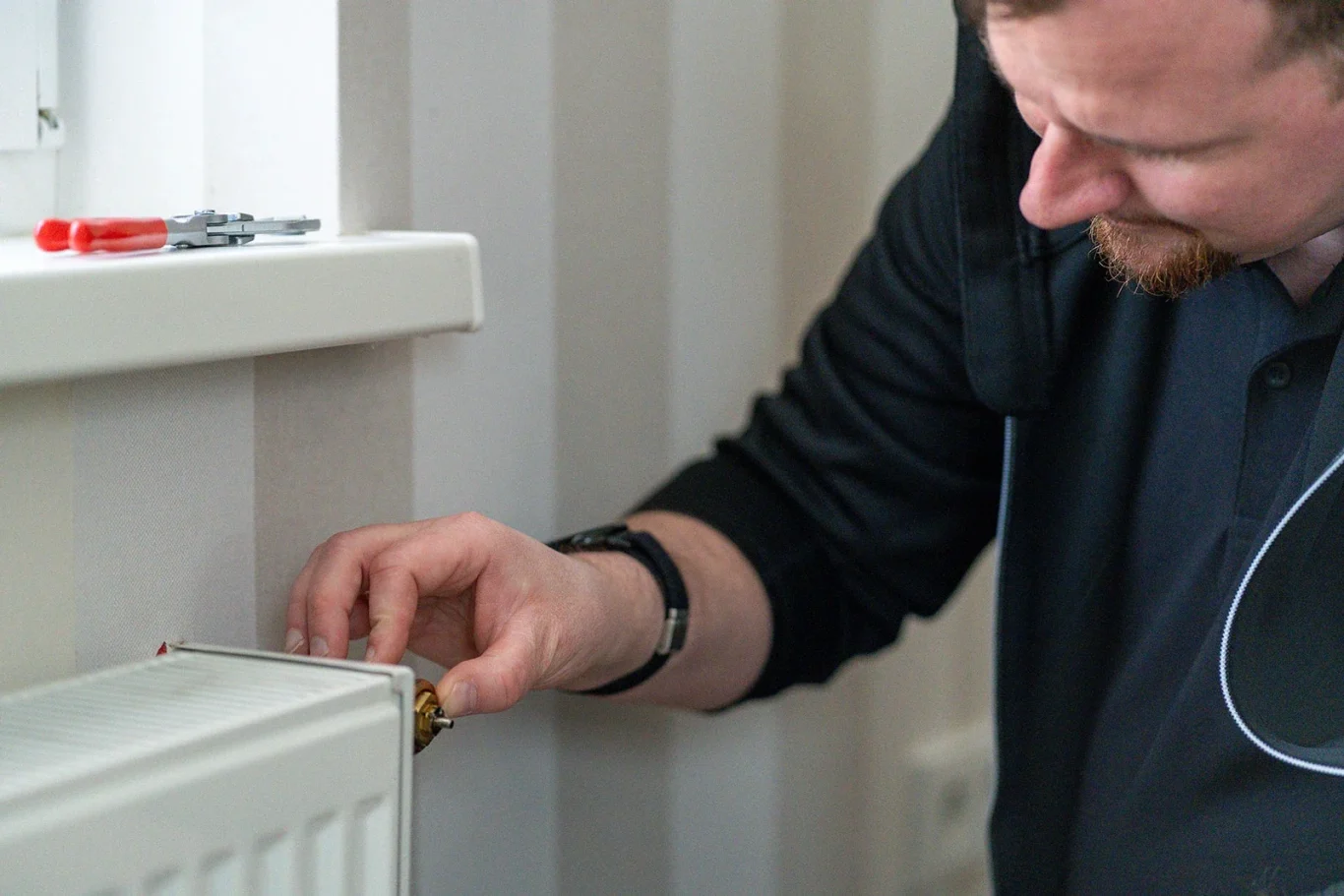 Energieberater Dennis Gauß führt einen hydraulischen Abgleich an einem Heizkörperventil durch, um die Effizienz der Heizungsanlage in Mainz 