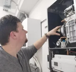 Energieberater bei der technischen Prüfung einer Heizungsanlage.