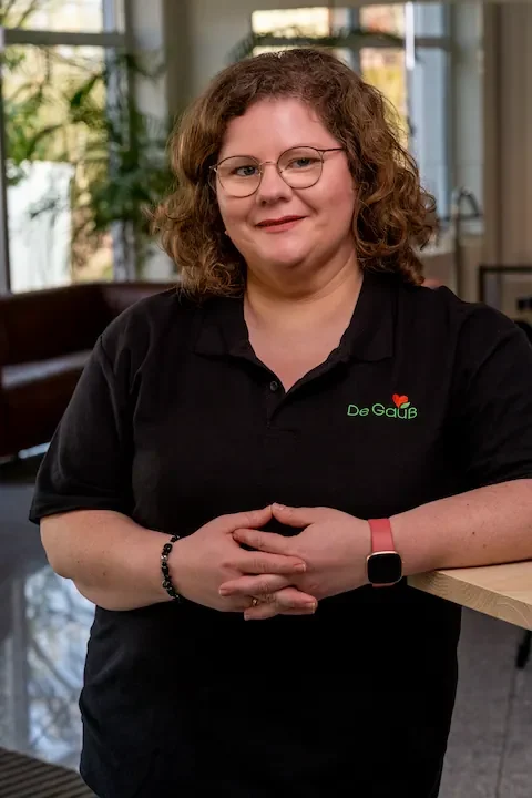 Andrea Gauß – Ihre Expertin für Förderservice & Organisation Andrea Gauß von Energieberater De Gauß lächelt sympathisch in schwarzer Arbeitskleidung mit Firmenlogo – sie leitet das Backoffice und den F